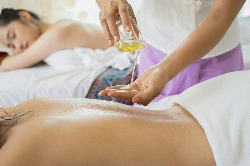 A person receiving a massage with oil being applied to their back. 3