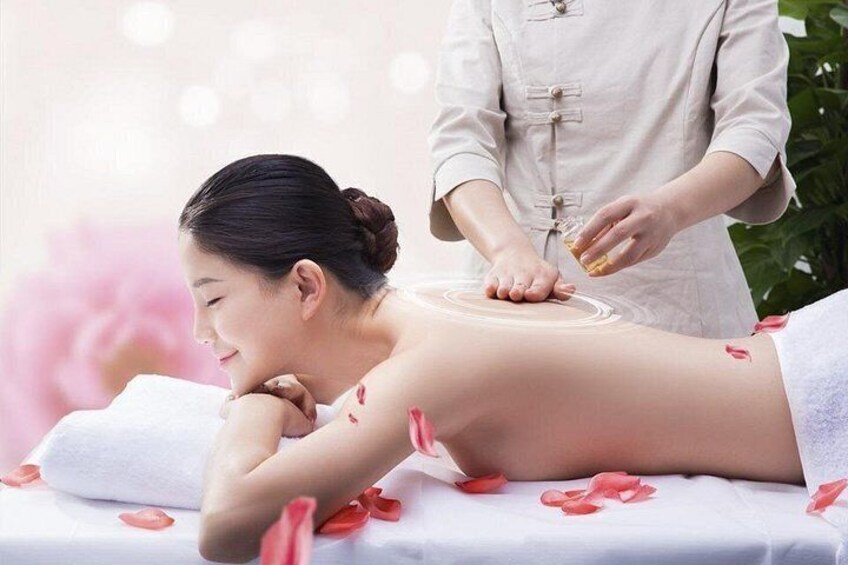 A person receiving a massage with rose petals on the massage table. 2