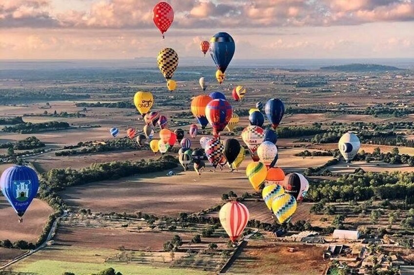 Un paysage où l’on peut admirer de nombreuses montgolfières de différentes couleurs et de différents modèles. 2
