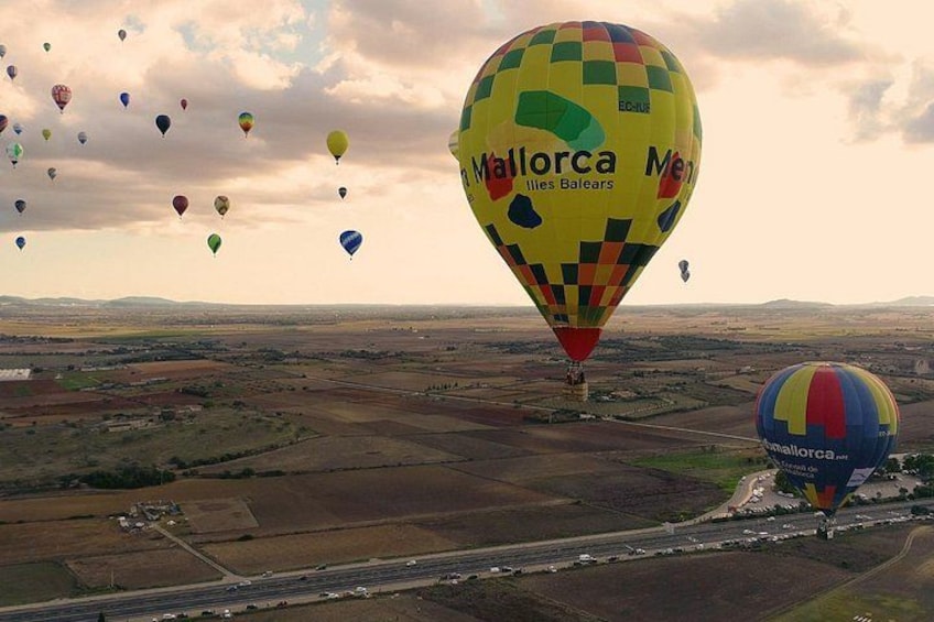 Festival de globos aerostáticos con múltiples globos, incluyendo uno con la leyenda 'Mallorca Mes Meses'. 2