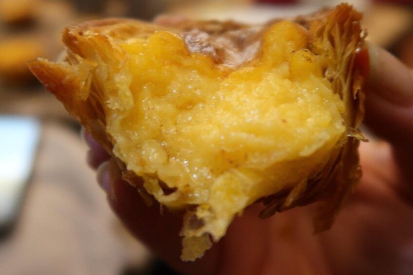 A close-up of a pastry with a flaky crust and a creamy filling. 1