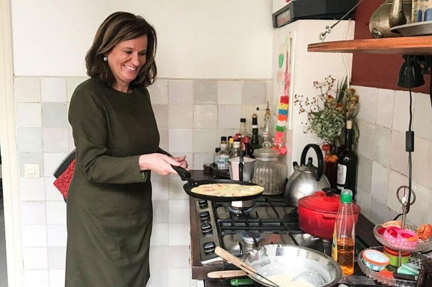 A person cooking in a kitchen with a frying pan, stove, and various kitchen items. 1