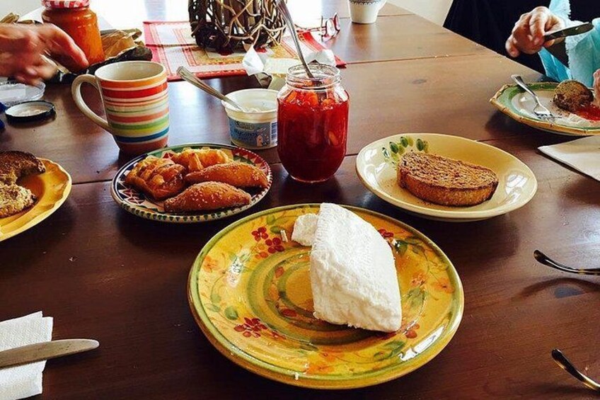 A table with various food items including bread, pastries, and a jar of jam. 4