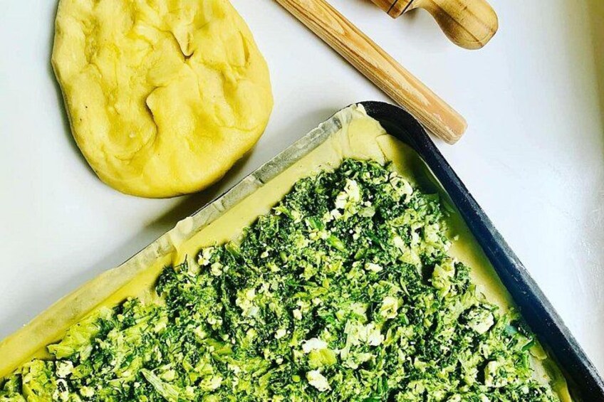 A tray of food with broccoli and a piece of dough. 5