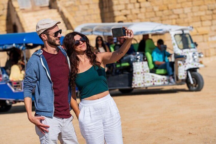 Ein Paar macht ein Selfie, im Hintergrund ein Tuk-Tuk. 4