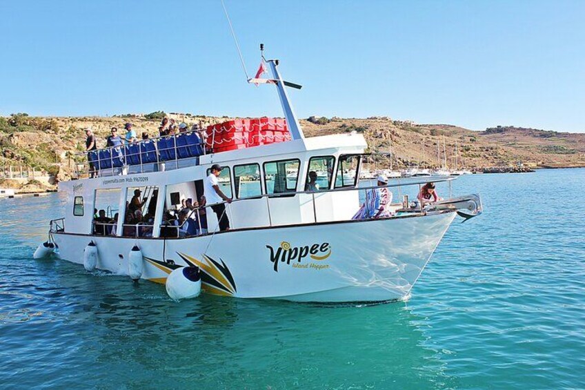 A boat named 'Vipppee' with passengers, clear blue water, and a hilly landscape in the background. 4