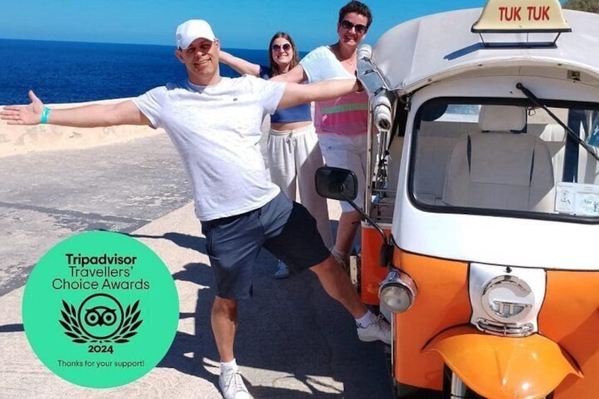 Ein Rikshaw steht am Meer mit blauem Himmel im Hintergrund. 2