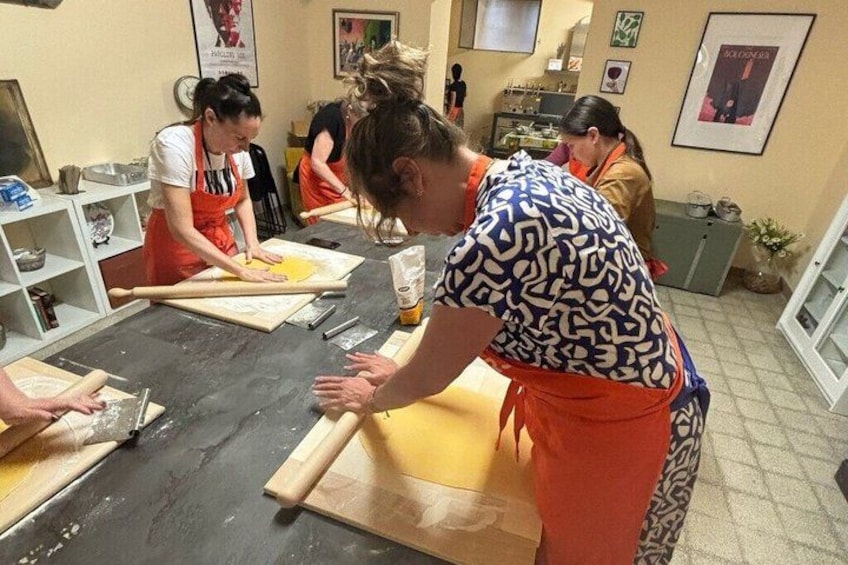 Un groupe de personnes participait à une activité culinaire, utilisant des rouleaux à pâtisserie et de la pâte sur une table. 3