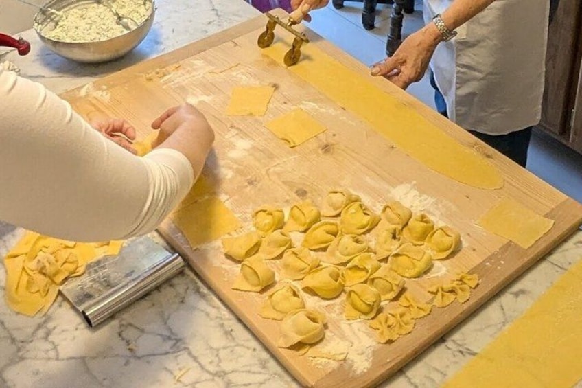 Une personne qui étale de la pâte sur une surface en bois à l'aide d'un rouleau à pâtisserie. 2