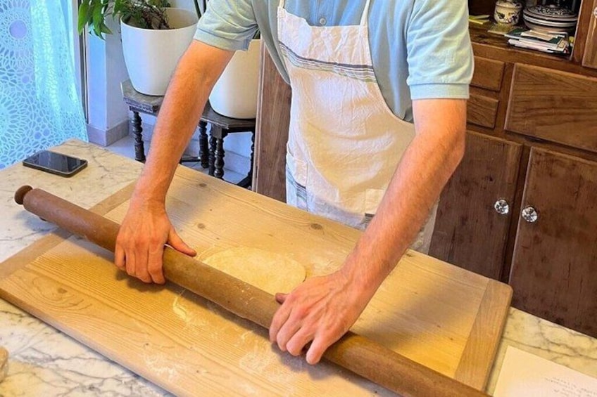 Une personne utilisant un rouleau à pâtisserie sur une surface en bois. 5