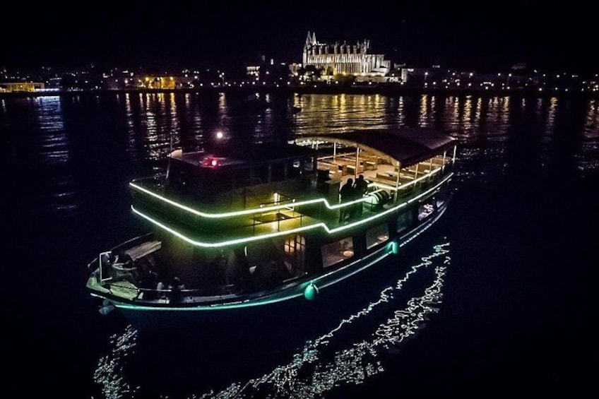 Ein hell beleuchtetes Boot mit Neonlichtern auf dem Wasser in der Nacht. 1