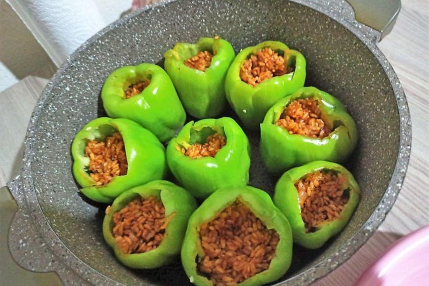 A pot containing several stuffed green bell peppers. 2