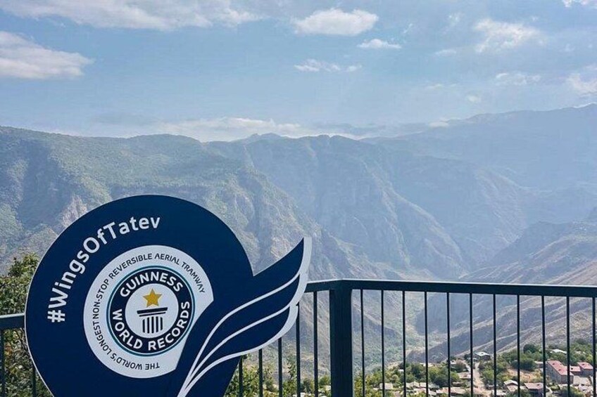 Un cartel de Guinness World Records con un paisaje montañoso al fondo. 3