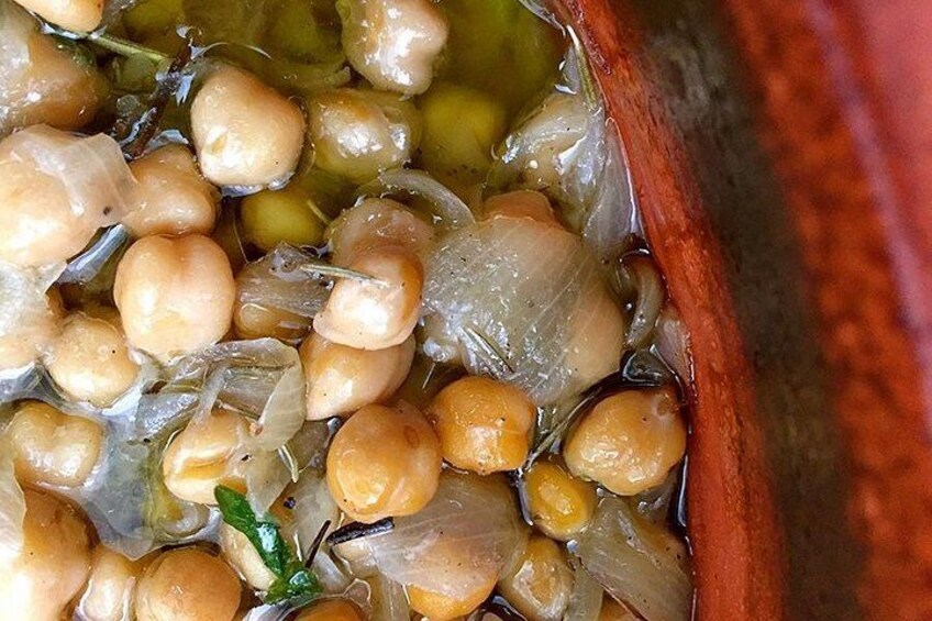 A close-up of a cooking pot with chickpeas and onions. 5