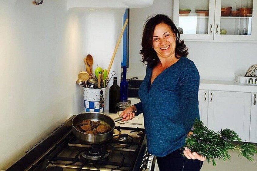 A person cooking in a kitchen with a stove, pots, and utensils. 1