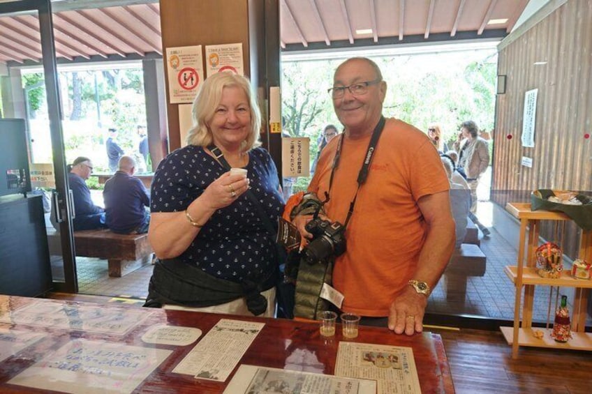 Two people standing at a counter with papers and a camera. 1