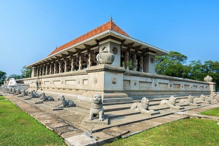 Een tempel met een rood dak, stenen leeuwen en een verzorgd gazon. 5