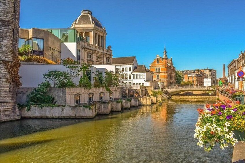 Un canal flanqueado por edificios, un puente y un cielo azul despejado. 5