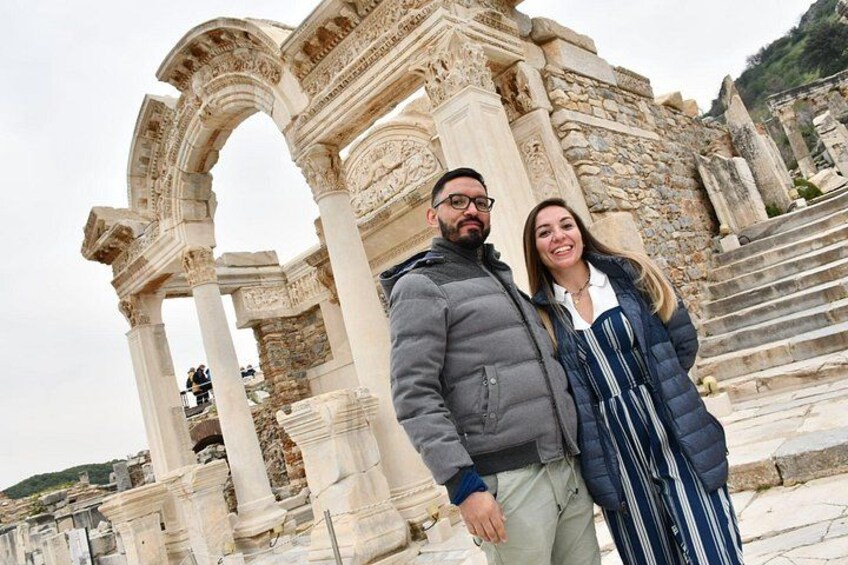 A couple standing in front of ancient ruins with columns and arches. 3
