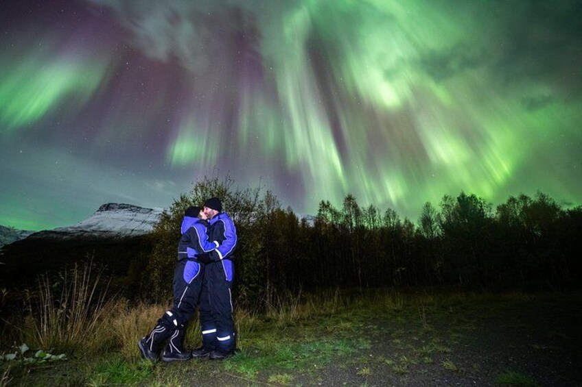 Two people embracing under the Northern Lights. 4