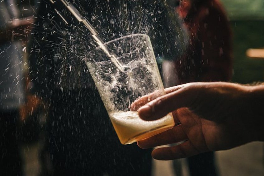 A hand holding a glass with a liquid being poured into it. 5