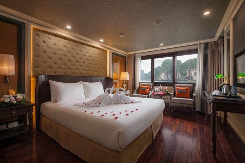 A hotel room with a large bed, a wooden floor, a view of mountains, and a desk with a lamp. 5