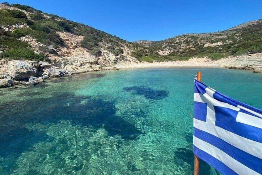 Mare blu intenso con un litorale roccioso e una bandiera. 1