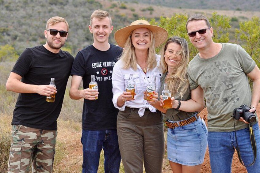 Group of tourists on a safari holding up a glass of cider in Addo Elephant National Park 2
