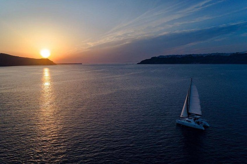 A sailboat on calm waters with a sunset in the background. 1