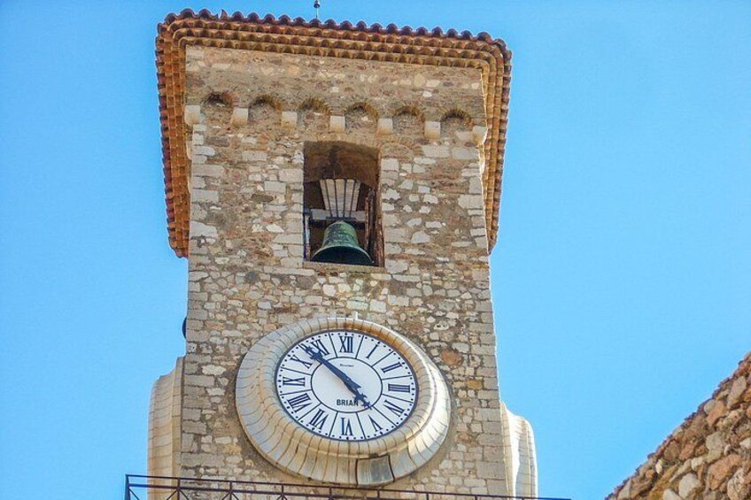 A clock tower with a bell and a clear blue sky. 5