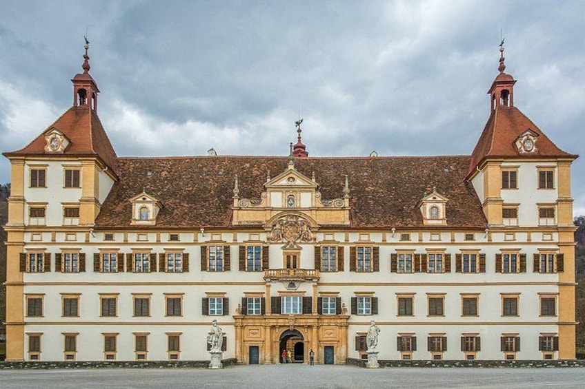 Un edificio storico con una facciata simmetrica, due torri imponenti e un ingresso centrale con una statua. 2