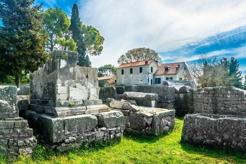 Ancient stone ruins with a modern building in the background. 4