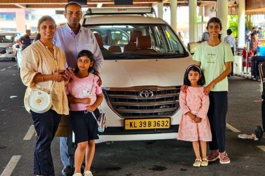 A family posing in front of a van with a visible license plate. 5