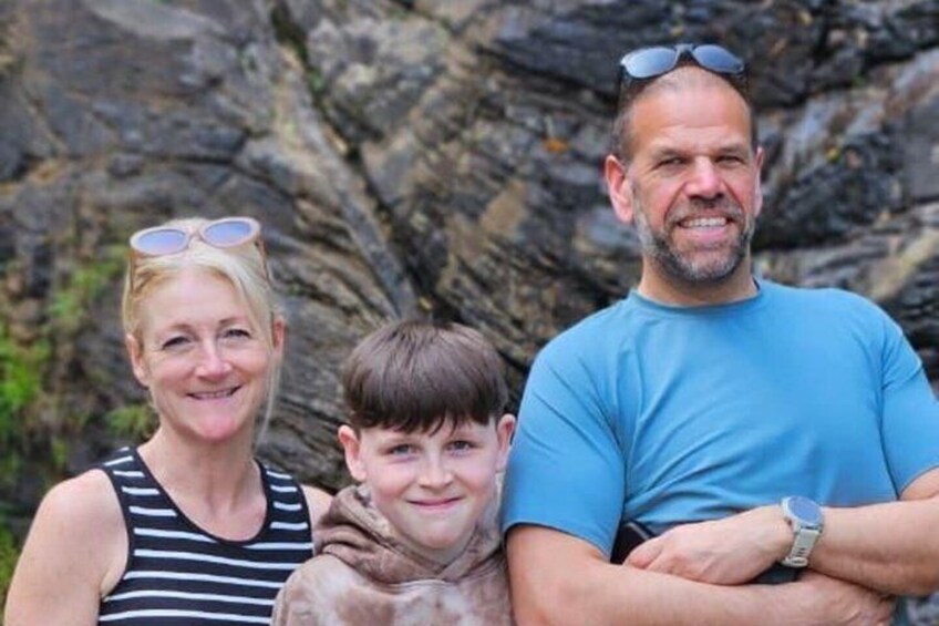 A family with a dog in front of a rocky cliff. 4