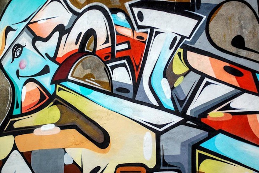 Et farverigt graffiti-vægmaleri med abstrakte former og markante linjer. 4