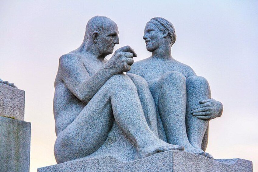 A stone sculpture of two figures seated and conversing. 3