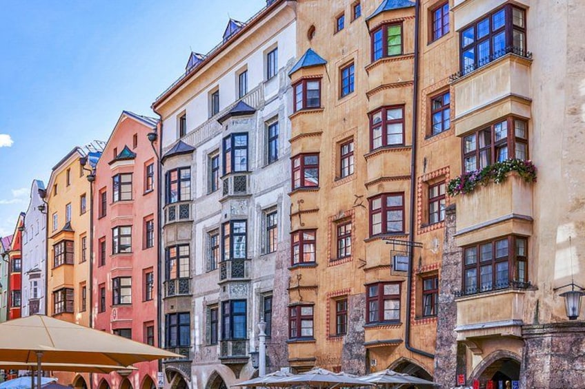 A row of colorful historic buildings with distinct architectural styles, including arched windows and decorative facades. 2
