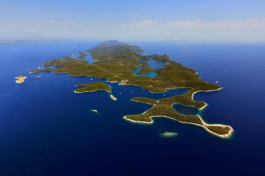 An aerial view of a large island with multiple smaller islands surrounded by deep blue ocean. 5