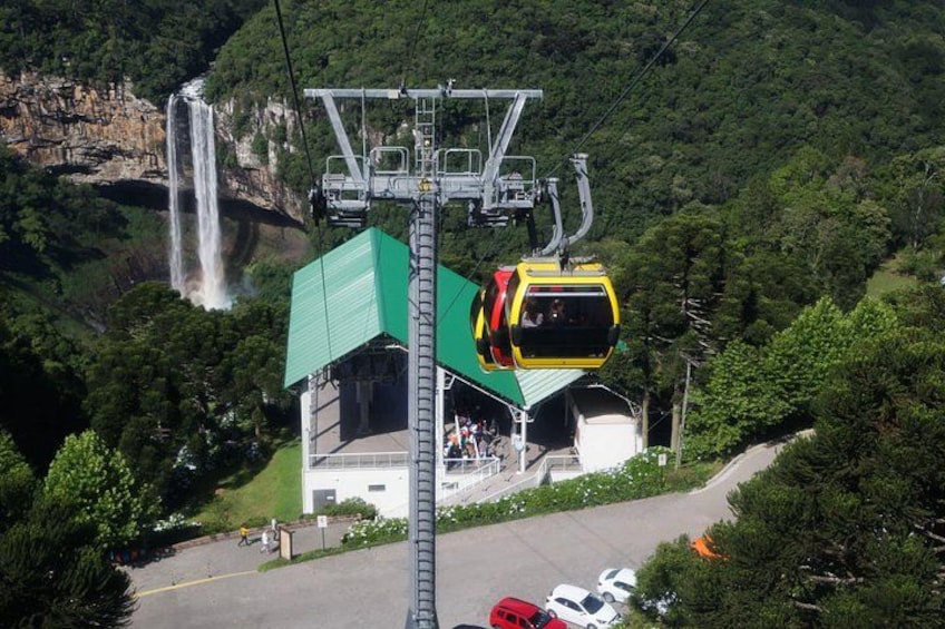 Un télésiège dans une station de montagne, avec une cascade en arrière-plan. 2