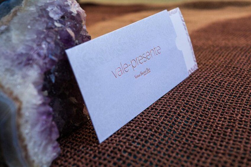 Tarjeta de regalo con la inscripción 'vale-presente' y 'Katia Street' sobre una superficie texturizada. 5