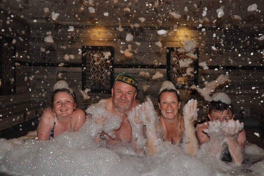 Un gruppo di persone in una baita di legno dall'interno rustico, circondata dalla neve. 1