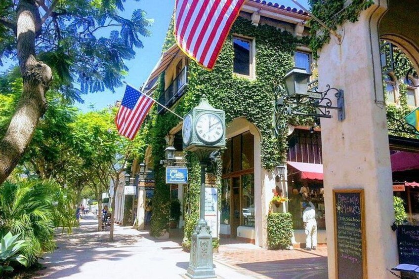 Une rue bordée d’immeubles, avec des drapeaux américains, une horloge et un panneau indicateur. 5