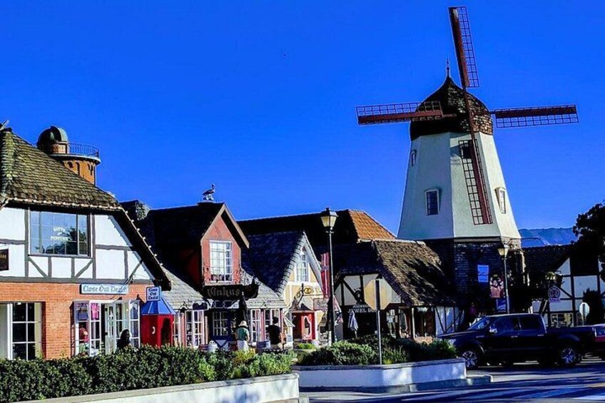 Un moulin à vent traditionnel, une rangée de maisons à colombages et un ciel bleu azur. 4