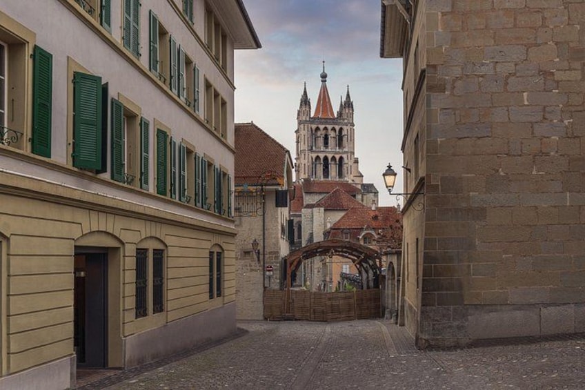Een geplaveid straatje, historische gebouwen en een kerktoren. 4