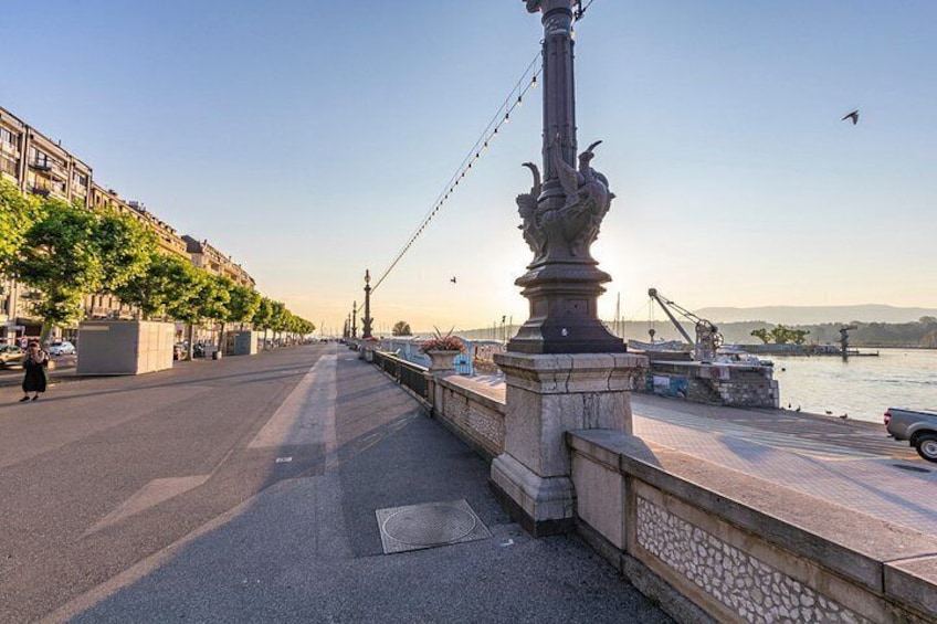 Un ponte pedonale con una colonna decorativa, un lungomare ed edifici lungo la riva. 4