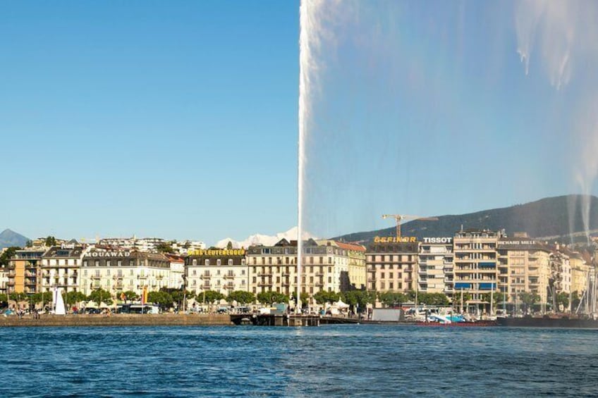 Una veduta urbana sul lungomare, con una fontana importante, edifici e cielo sereno. 1