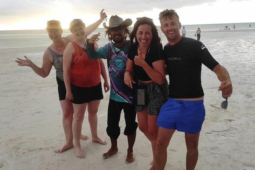 A group of people on a beach with the ocean in the background. 3