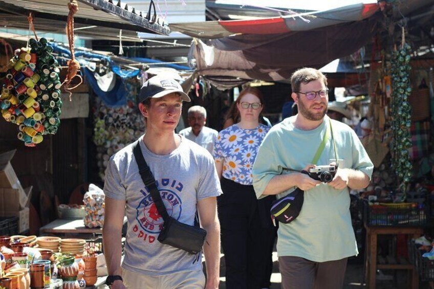 A market with various goods on display, including hanging items and a person holding a camera. 4