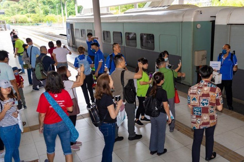 A train station platform with passengers and staff. 3