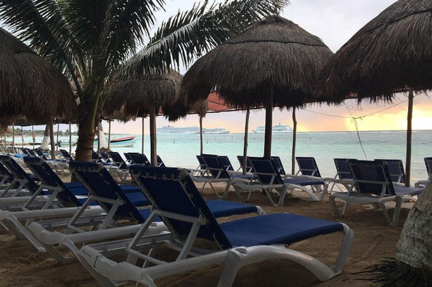 Beach chairs, palm trees, and thatched umbrellas. 1